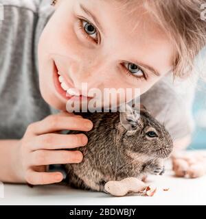 Portrait de la jeune fille avec écureuil et noix de dégu, gros plan. Banque D'Images