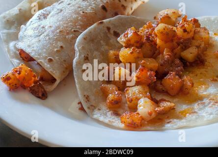 Potatoe et chorizo tacos dans des tortillas de farine dans le cadre d'un petit déjeuner mexicain, la cuisine mexicaine traditionnelle. Banque D'Images