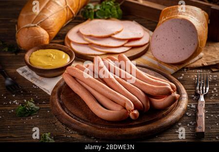 Saucisses de porc fraîches pour chiens chauds, pour barbecue ou gril sur planche à découper en bois Banque D'Images