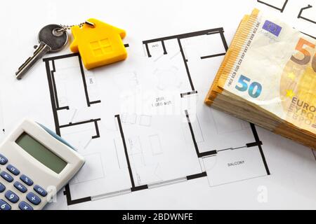 Quelques billets en euros, une calculatrice et une clé de maison en plus des plans de construction. Banque D'Images