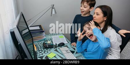 Famille parler sur appel vidéo pendant que la fille grimaces Banque D'Images