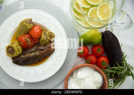 Les aubergines sont farcies d'agneau à la viande et de riz. Plican . remplissage de l'aubergine . Aubergine, poivrons, tomates . Yaourt dans un bol marron . Citron haché dans un Banque D'Images