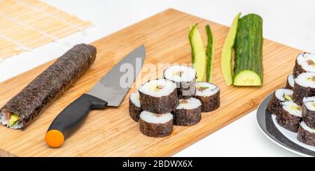 Rouleau à sushi plat japonais ingrédients et couteau sur le plateau en bambou Banque D'Images