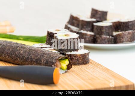 Rouleau à sushi plat japonais roulent les ingrédients et couteau sur la planche de la cuisine en bambou Banque D'Images