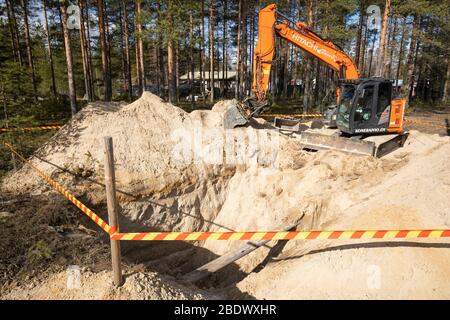 L'excaveur orange Hitachi et un fossé profond dans un sol sablonneux , Finlande Banque D'Images