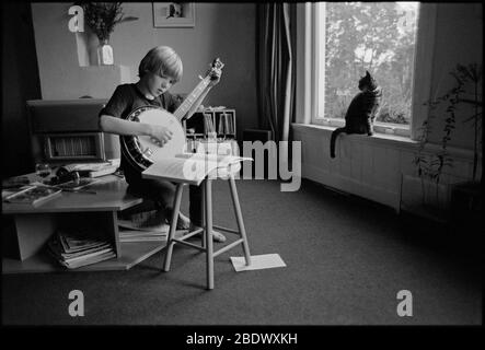 Photo noir et blanc vintage d'un petit garçon qui pratique le banjo Banque D'Images