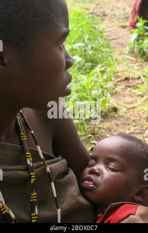 Portrait d'une jeune mère Hadza avec son bébé, Hadza ou Hadzabe est une petite tribu de chasseurs cueilleurs. Photographié au lac Eyasi, Tanzanie Banque D'Images