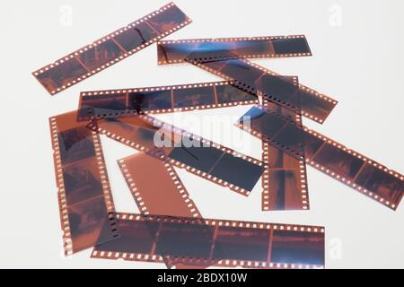 Tant de bandes de négatifs photographiques disposés de manière aléatoire sur un fond blanc. Banque D'Images