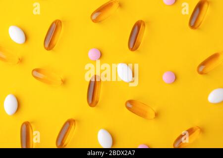 Assortiment de vitamines, pilules, gels oméga 3, comprimés à mettre sur la surface jaune pendant la thérapie de guérison, su alimentaire Banque D'Images