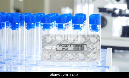 Bouchons bleus Vider les tubes à essai avec les pilules de coronavirus ou les pilules de drogue de Covid-19 dans le laboratoire Banque D'Images