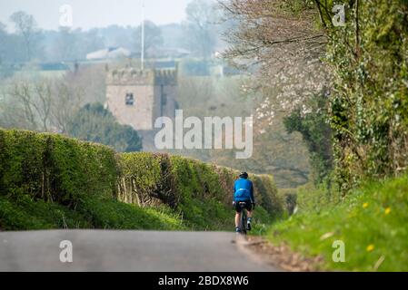 Preston, Lancashire, Royaume-Uni. 10 avril 2020. Une belle journée de cyclisme aime son exercice quotidien sur les ruelles de Chipping, Preston, Lancashire avec l'église Saint-Bartholomews, en arrière-plan fermée pour le culte pendant le week-end de Pâques. Crédit: John Eveson/Alay Live News Banque D'Images