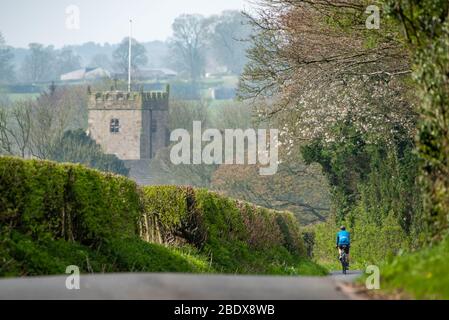 Preston, Lancashire, Royaume-Uni. 10 avril 2020. Une belle journée de cyclisme aime son exercice quotidien sur les ruelles de Chipping, Preston, Lancashire avec l'église Saint-Bartholomews, en arrière-plan fermée pour le culte pendant le week-end de Pâques. Crédit: John Eveson/Alay Live News Banque D'Images