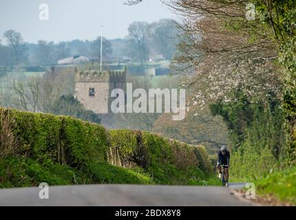 Preston, Lancashire, Royaume-Uni. 10 avril 2020. Une belle journée de cyclisme aime son exercice quotidien sur les ruelles de Chipping, Preston, Lancashire avec l'église Saint-Bartholomews, en arrière-plan fermée pour le culte pendant le week-end de Pâques. Crédit: John Eveson/Alay Live News Banque D'Images