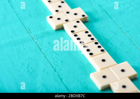 Jouer aux dominos sur une table en bois bleu Banque D'Images