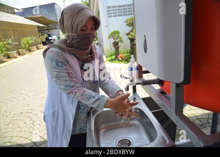 Bandung, Indonésie. 10 avril 2020. Une femme portant un masque facial, se lavant la main avec du savon dans un évier à Bandung, Java Ouest, Indonésie. 10 avril 2020. L'Organisation mondiale de la santé (OMS) recommande que les gens se lassent toujours les mains pour empêcher la propagation du Coronavirus COVID-19. (Photo de ASEP Solihin/INA photo Agency/Sipa USA) crédit: SIPA USA/Alay Live News Banque D'Images