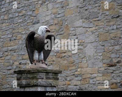 Ancienne sculpture en pierre sculpté aigle sur pilier par mur. Avec copyspace. Banque D'Images