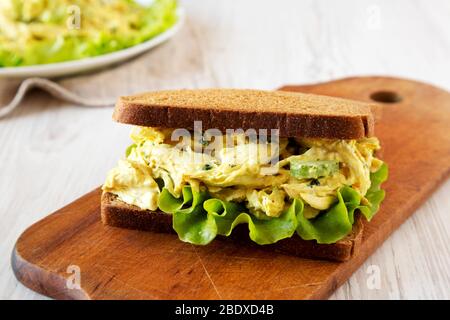 Sandwich au poulet au couronnement fait maison sur un panneau rustique en bois sur fond blanc en bois, vue à bas angle. Gros plan. Banque D'Images