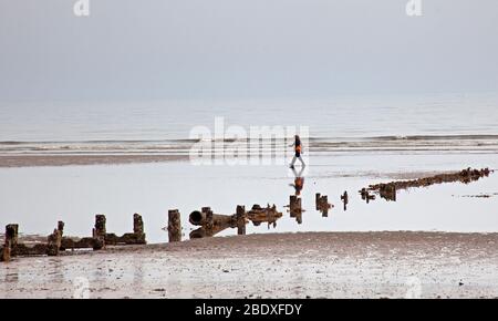 Portobello Beach, Édimbourg, Écosse, Royaume-Uni. 10 avril 2020. Photo: Misty matin donnant un look presque monochromatique aux images. Les gens qui restent bien éloignés les uns des autres si physique social distancing et un chien qui semble s'en tenir à la langue du Photographe sur la plage de sable avec la marée bien dehors. Crédit: Arch White/ Alay Live News. Banque D'Images