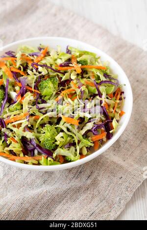 Brocoli Slaw déchiqueté maison dans un bol blanc sur tissu, vue latérale. Gros plan. Banque D'Images