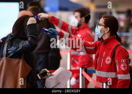 (200410) -- ROME, 10 avril 2020 (Xinhua) -- un membre du personnel italien de la Croix-Rouge vérifie la température des passagers arrivant à la gare Termini à Rome, Italie, le 9 avril 2020. La pandémie de coronavirus a fait 18 279 morts en Italie, ce qui porte le nombre total d'infections, de morts et de reprises à 143 626 jeudi, selon les dernières données publiées par le Département de la protection civile du pays. (Ferrovie Italiane Press Office/Handout via Xinhua) Banque D'Images