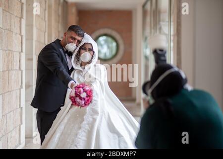 Bethléem, camp de réfugiés palestiniens de Deheisheh près de la ville de Bethléem, en Cisjordanie. 10 avril 2020. Un photographe palestinien prend des photos pour la groom, Ishaq Mulleh, et sa mariée, Shima'al-Titi, dans le camp de réfugiés palestiniens Deheisheh près de la ville de Bethléem, en Cisjordanie, le 10 avril 2020. Porter des masques et des gants comme mesures préventives, le couple a célébré son mariage lors de l'éclosion de COVID-19. Crédit: Luay Sababa/Xinhua/Alay Live News Banque D'Images