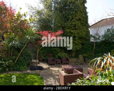 Jardin anglais offrant un havre de paix pendant le verrouillage de Coronavirus. Un petit coin de paradis extérieur avec un feuillage luxuriant qui éclate dans la vie printanière Banque D'Images