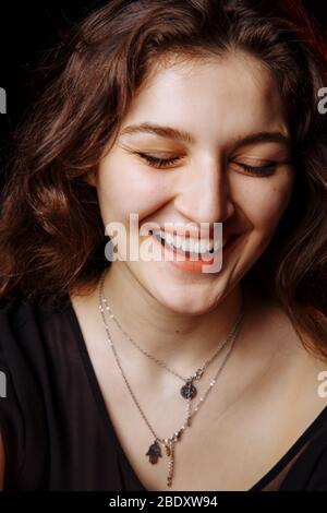 La jeune brunette rid de gaieté. Yeux fille fermée Banque D'Images