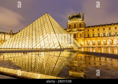 Vue nocturne du célèbre musée du Louvre avec la Pyramide du Louvre, Paris. Banque D'Images
