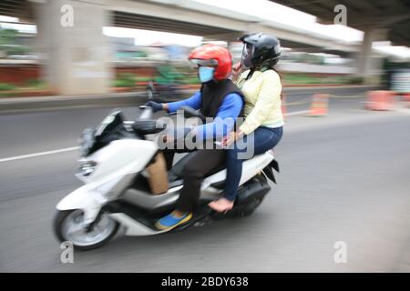 Jakarta, Indonésie. 10 avril 2020. Les passagers de moto privés sont toujours autorisés à voyager avec les passagers, le conducteur et le passager doivent porter des masques et des gants, pendant la mise en œuvre des restrictions sociales à grande échelle (PSBB) dans la région de la capitale spéciale de Jakarta. Attendu que le transport à deux roues basé sur des applications est limité à l'utilisation autorisée uniquement pour le transport de marchandises. (Photo de Kuncoro Widyo Rumpoko/Pacific Press) crédit: Pacific Press Agency/Alay Live News Banque D'Images