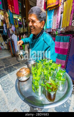 Homme qui verse du thé à la menthe à la médina. Banque D'Images