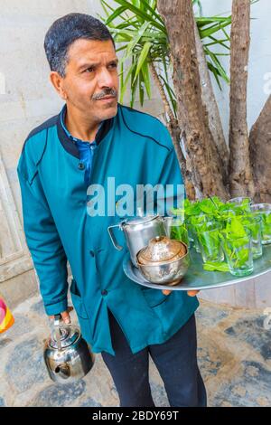 Homme qui verse du thé à la menthe à la médina. Banque D'Images