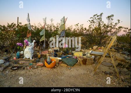 Une petite statue heureuse de Bouddha marque cette tombe dans le cimetière Terlingua de l'ouest du Texas, où les tombes sont marquées par des embellissements faits à la main. Banque D'Images