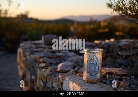 Une bougie catholique se trouve à côté d'une tombe dans le cimetière Terlingua, dans l'ouest du Texas, où les tombes sont marquées par des embellissements faits à la main. Banque D'Images