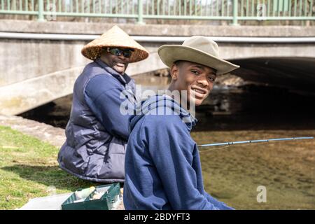 Berks County, Pennsylvanie, États-Unis-14 mars 2020: Jeune homme poissons avec père dans le parc public local le jour chaud de printemps. Banque D'Images