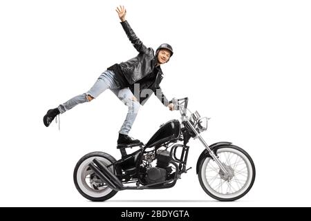 Jeune darediable debout sur le siège et à cheval un chopper moto isolé sur fond blanc Banque D'Images