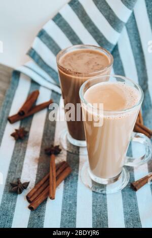 Café glacé avec lait dans de grands verres, tasses de café savoureux à la frappe, Latte machiato, deux tasses de cappuccino avec des bâtons de cannelle et des étoiles anis Banque D'Images