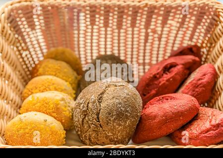 Panier en osier rustique avec une sélection de plusieurs pains artisanaux portugais fraîchement cuits exposés à Porto, Portugal Banque D'Images