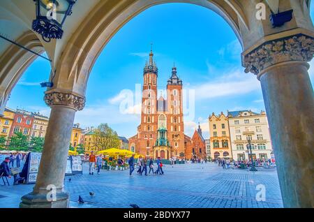 CRACOVIE, POLOGNE - 12 JUIN 2018 : vue sur l'étonnante basilique Sainte-Marie sur le lac Mariacki à travers les arcades de Sukienice, le 12 juin à Cracovie Banque D'Images