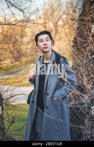 Portrait d'une belle fille dans le parc par temps chaud d'automne. Une jeune femme marche dans la forêt de printemps. Tons chauds. Banque D'Images