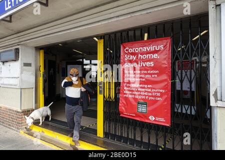 Homme portant un masque facial contre COVID-19 en quittant la station de métro de Londres, pendant le maintien à l'échelle nationale pour lutter contre la pandémie de coronavirus Banque D'Images