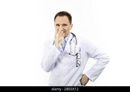 Médecin en pelage blanc regardant les ongles sceptiques et effrayés, mordant nervosité Banque D'Images