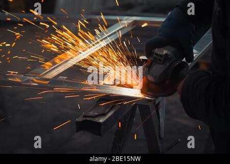 Meuleuse électrique. Meule électrique sur structure en acier dans une usine. Usine de portes. Étincelles de la meule en Palestine, Hébron Banque D'Images