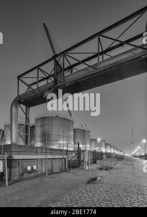 Scène nocturne avec un grand silo et un dépassement de pipeline à l'usine de production pétrochimique, Port d'Anvers. Banque D'Images