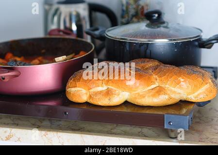 Plaque chaude pour le Sabbat, un pot de poisson épicé cuit avec des poivrons et des tomates, pot de cholent ou Hamin en hébreu et pain spécial de challah dans la cuisine juive. Cuisine traditionnelle pour le Shabbat juif. Banque D'Images