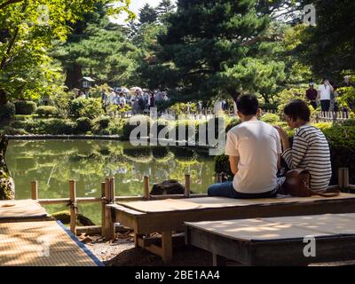 Kanazawa, Japon - 28 septembre 2015 : jeune couple assis sur un banc dans le jardin de Kenrokuen profitant de paysages lors d'une journée ensoleillée Banque D'Images