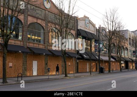 Vancouver, Canada, 10 avril 2020. Un homme marche devant les boutiques de la rue Robson au centre-ville de Vancouver pendant la pandémie COVD-19. Banque D'Images