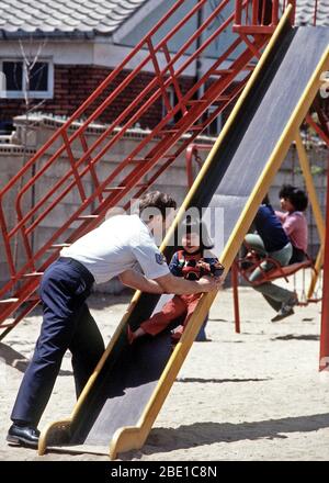 La Corée du Sud 1980 - Un sergent américain joue avec un enfant Amérasiens (l'enfant d'une femme coréenne et un militaire américain) au cours d'une visite à la maison pour les enfants amérasiens Vincents. Banque D'Images