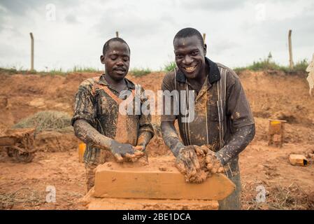 Kampala / Ouganda - 20 septembre 2016 : hommes noirs travaillant dans l'usine de briques de boue dans la capitale de l'Ouganda Banque D'Images