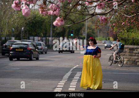 Stockport, Grand Manchester, Royaume-Uni. 10 avril 2020. Rebecca Williamson, une fille vêtue de costumes blancs neige, encourage les gens dans le cadre de la pandémie COVID-19 à Stockport près de Manchester, Grande-Bretagne, le 10 avril 2020. Rebecca, l'une de ceux qui s'habillés comme des bandes dessinées ou des personnages de contes de fées, a essayé de tromper les gens dans le public pendant l'épidémie. Crédit: Jon Super/Xinhua/Alay Live News Banque D'Images