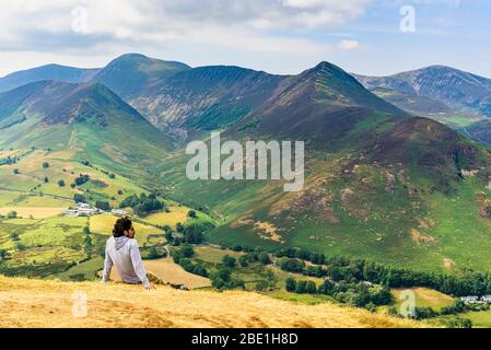 Un randonneur repose sur des cloches dans le district de Lake Anglais qui regarde la vallée de Newlands pour se fauver, y compris Grasmoor Causey Pike et Grisedale Pike Banque D'Images